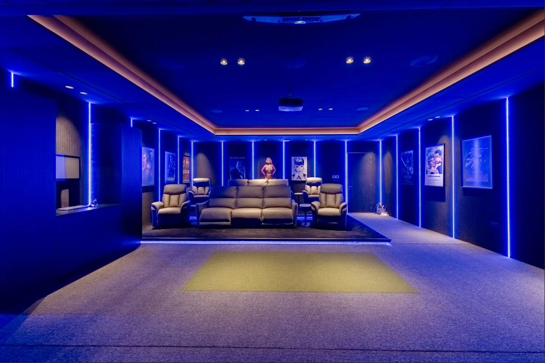 The private cinema with reclining seats under blue ambient lighting