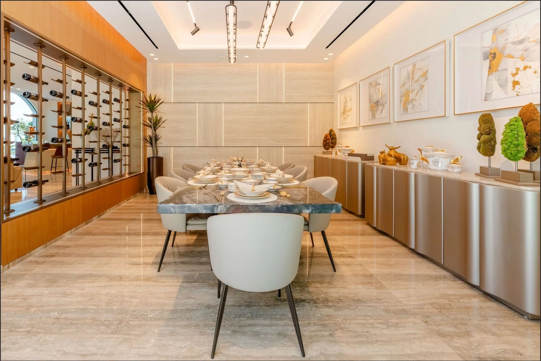 The formal dining room with a marble table, a lit wine wall and a bar