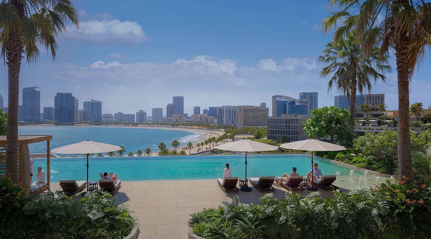 Infinity pool at Linar by Alef Group looking across Al Mamzar beach to the Sharjah and Dubai skyline