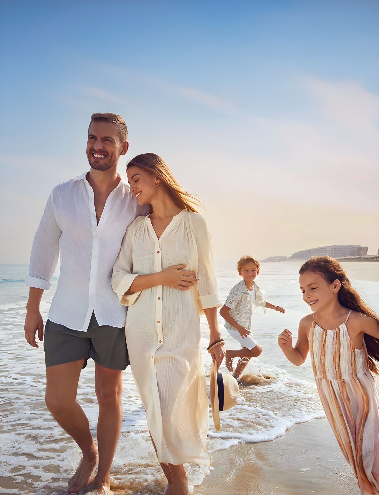 A family walking along the shoreline at Mamsha Beach