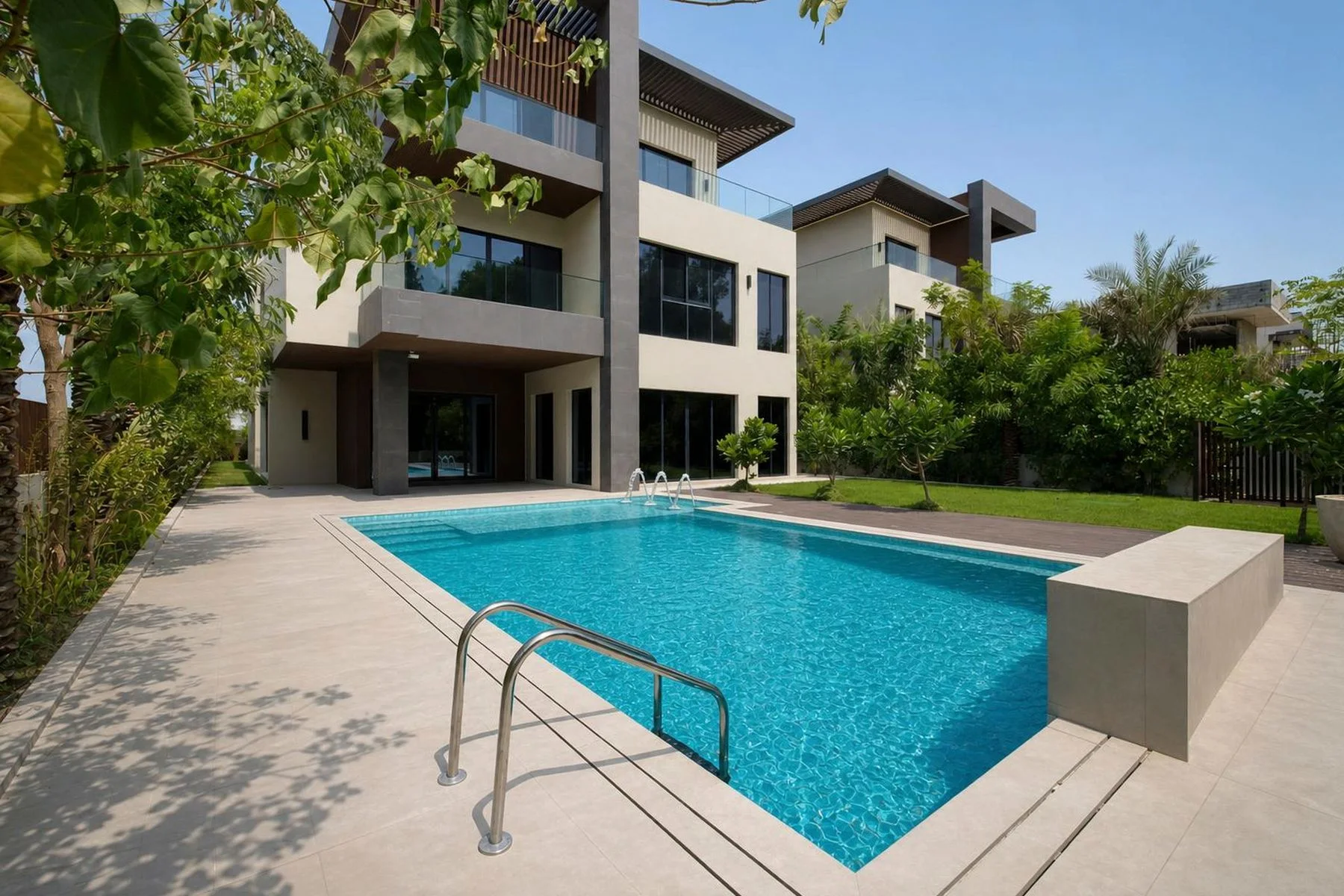 The private swimming pool and terrace of the mansion with its contemporary three-storey façade and mature trees behind