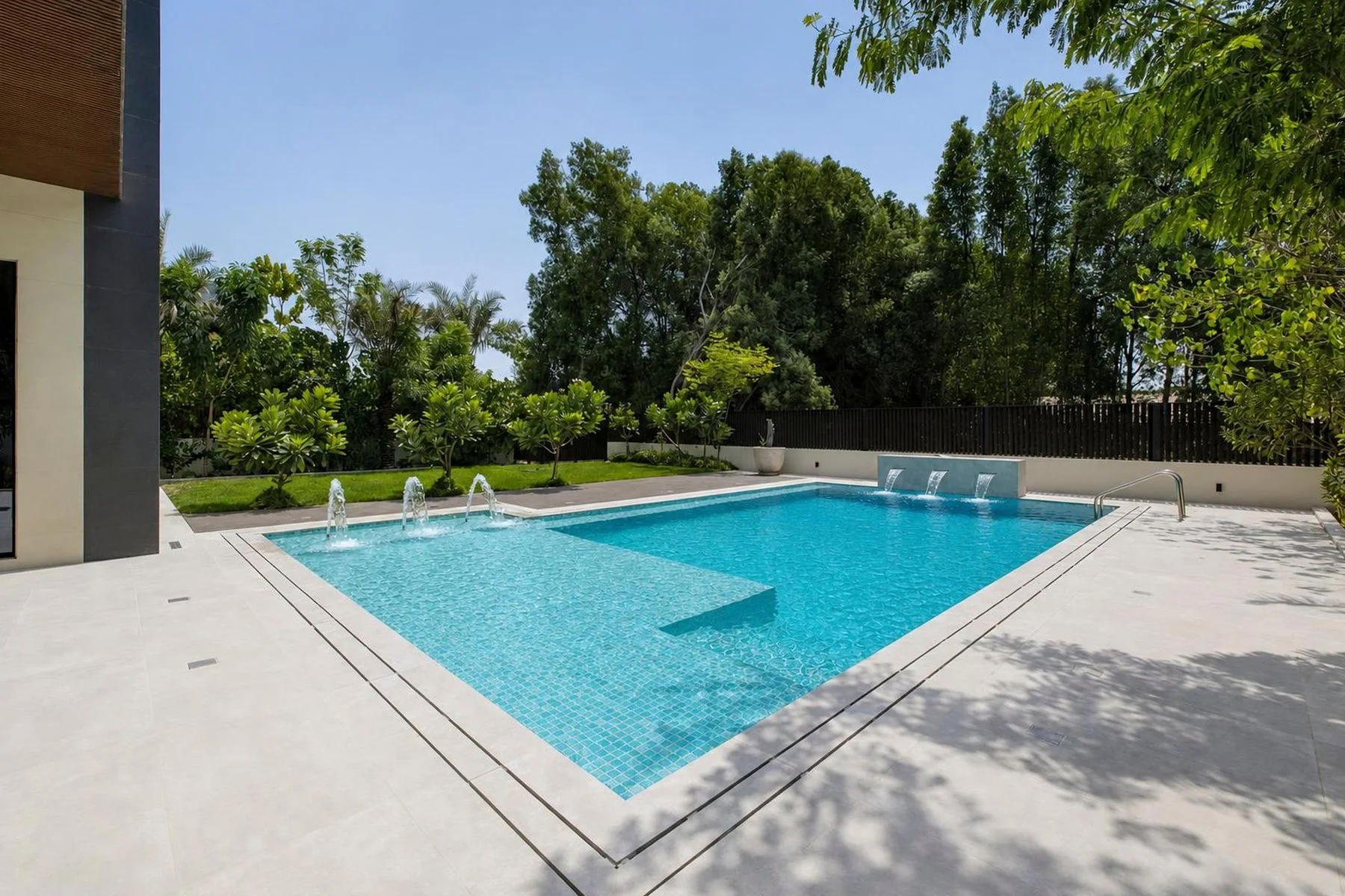The private pool and lawn at the back of the mansion, shaded by mature trees
